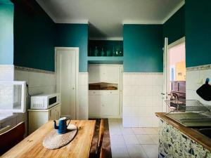 a kitchen with blue walls and a wooden table at Spacious Garden Villa in Lublin