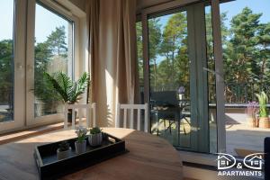 un salon avec une table et une grande fenêtre dans l'établissement Pine Tree House 10 D&D Apartments, à Międzywodzie