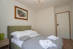 une chambre avec un lit avec deux serviettes dessus dans l'établissement Pine Tree House 10 D&D Apartments, à Międzywodzie