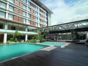 a swimming pool in front of a building at Mercure Padang in Padang