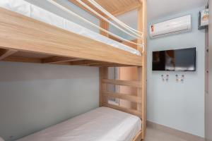 a bunk bed in a room with a tv and a bunk bed in a bedroom at Eco Resort Praia dos Carneiros Apt Luxo Beira Mar in Praia dos Carneiros +24 photos