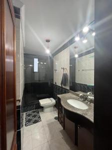 Un baño con lavabo, inodoro y espejo. en Guilhermina - Frente pro Mar!, en Praia Grande