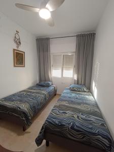 ein Schlafzimmer mit zwei Betten und einem Deckenventilator in der Unterkunft Blue Day Solo Familias in Puerto de Gandía + 3 Fotos