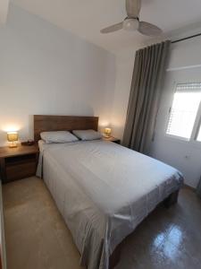 ein Schlafzimmer mit einem großen Bett und einem Deckenventilator in der Unterkunft Blue Day Solo Familias in Puerto de Gandía