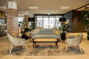 莱比锡Radisson Hotel Leipzig的有一张沙发和两把椅子的候诊室