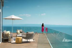 a woman walking on a boardwalk next to the ocean at Radisson Blu Resort & Spa in Split +37 photos