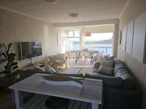 a living room with a couch and a table at Be Lazy with a Sea View in Jeffreys Bay
