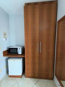 a microwave and a cabinet in a room at Flat com parque aquático in Caldas Novas