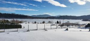 a snow covered field with a fence and a snow covered ground at Topolowa Miszkowice in Miszkowice