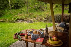 a table with a bowl of fruit and a bottle of wine at Chata Krajinka in Ždiar