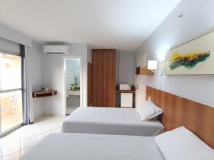 a hotel room with two beds and a window at Flat com parque aquático in Caldas Novas +20 photos