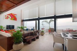 a living room with a couch and chairs and a table at Two-Story Beachfront Oasis in Puerto Vallarta