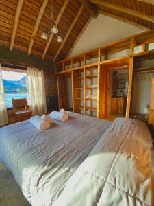 a bedroom with a large bed with two towels at Complejo Don Cirilo in Villa Pehuenia
