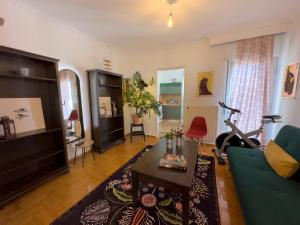 a living room with a green couch and a table at Spacious Artistic Flat With Private Parking in Thessaloniki