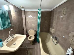 a bathroom with a tub and a toilet and a sink at Spacious Artistic Flat With Private Parking in Thessaloniki