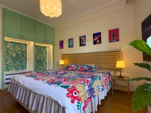 a bedroom with a large bed with a colorful bedspread at Spacious Artistic Flat With Private Parking in Thessaloniki