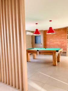 een kamer met een pingpongtafel en twee rode lampen bij Promenade Soho Campos dos Goytacazes - OFICIAL in Campos dos Goytacazes