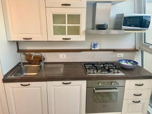 a kitchen with a sink and a stove top oven at Alerì Central Apartment - Zona Pedonale in Viareggio +2 photos