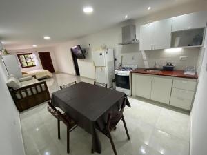 a kitchen with a table and chairs and a refrigerator at Estudio Alma in Miramar