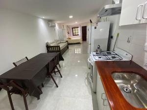 a kitchen with a table and a sink and a stove at Estudio Alma in Miramar +10 photos