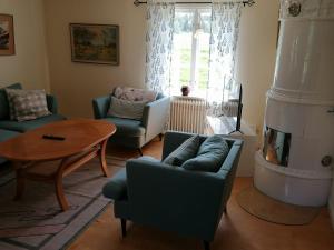 a living room with a couch and chairs and a table at Norsnäs Tempelbacken in Rengsjö