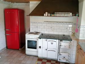 a kitchen with a white stove and a red refrigerator at Norsnäs Tempelbacken in Rengsjö