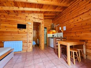 a kitchen and dining room with a wooden wall at Camping Ribera del Ara in Fiscal