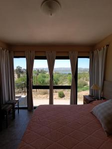 a bedroom with a bed and a large window at Complejo Refugio Playa Perelli in Villa Carlos Paz +22 photos