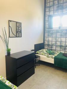 a bedroom with a bed and a dresser and a window at MoryńApartments R20 in Moryń