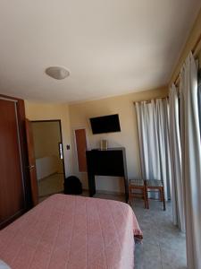 a bedroom with a bed and a flat screen tv at Complejo Refugio Playa Perelli in Villa Carlos Paz