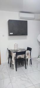 a dining room table with two chairs and a television at Lovely room near Balluta Bay RB in San Ġwann +7 photos