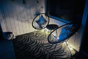deux chaises et une table sur un balcon la nuit dans l'établissement Apartment mit Grünblick & Wintergarten im Schwarzwald, à Löffingen