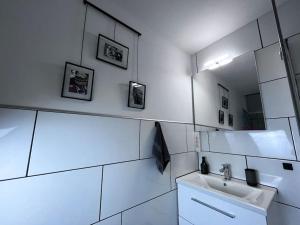 une salle de bain blanche avec un lavabo et un miroir dans l'établissement Apartment mit Grünblick & Wintergarten im Schwarzwald, à Löffingen 24 autres photos