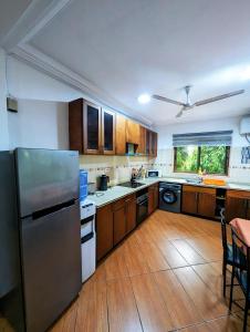 a kitchen with a stainless steel refrigerator and wooden cabinets at Luxor garden 1 bedroom Apartment 3A in Accra