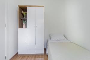 a white bedroom with a bed and a cabinet at Apto 2 dorm I Prox ao Transamérica Expo e Vibra SP in Sao Paulo