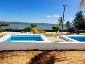 two swimming pools with the ocean in the background at Canto das Amêijoas in Inhambane