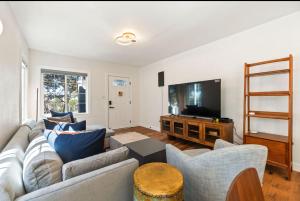 Una sala de estar con un sofá y un televisor de pantalla plana. en Berkeley Heaven, en Berkeley