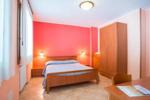 a bedroom with a bed and a red wall at Colli Berici in Arcugnano