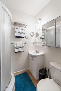 Un baño blanco con lavabo e inodoro. en Berkeley Heaven, en Berkeley 9 fotos más