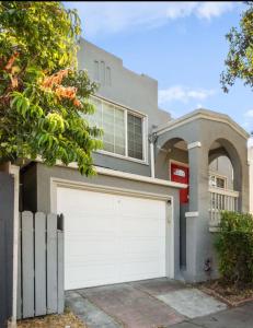 Una casa con una puerta de garaje blanca en frente. en Berkeley Heaven, en Berkeley