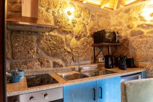 a kitchen with a sink and a tv on a wall at Refúgios da Natureza in Entre -os- Rios +12 photos