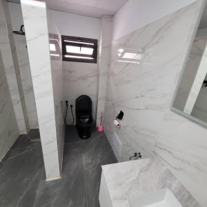 a white bathroom with a sink and a mirror at Studio équipé in Ndiorhorh +9 photos