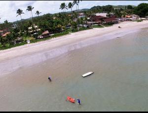 ein paar Leute im Wasser am Strand in der Unterkunft Villas Vovô Marcos - Beira Mar in São José da Coroa Grande