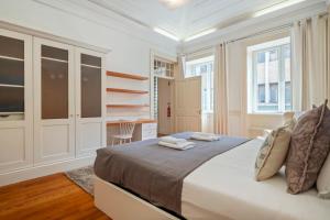 ein weißes Schlafzimmer mit einem Bett und einem Schreibtisch in der Unterkunft Villa Diniz by Madeira Dream Stays in Funchal