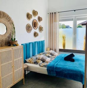 a bedroom with a blue bed and a window at MoryńApartments R20 in Moryń