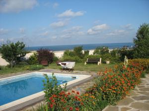 a swimming pool with a bench and flowers in a yard at Villa Magnet in Lozenets