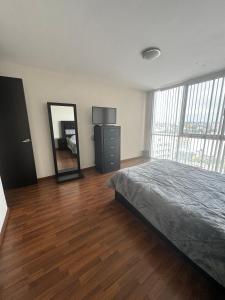 a bedroom with a bed and a dresser and a mirror at Amplio departamento con balcon in San Luis Potosí +8 photos