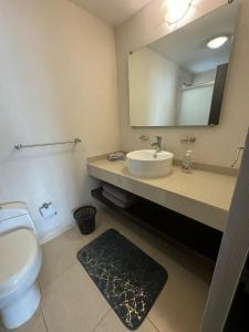 a bathroom with a toilet and a sink and a mirror at Amplio departamento con balcon in San Luis Potosí +8 photos