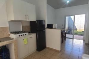 cocina con nevera negra y fogones en Residencia en Megápolis, San Miguel, en San Miguel