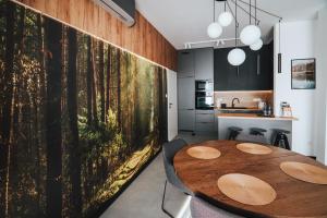a dining room with a table and a large painting on the wall at Apartament Przy Baryczy Milicz in Milicz